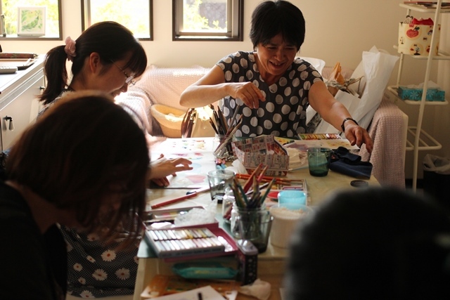 大人と子供と一緒の教室でたのしく絵を描いている写真