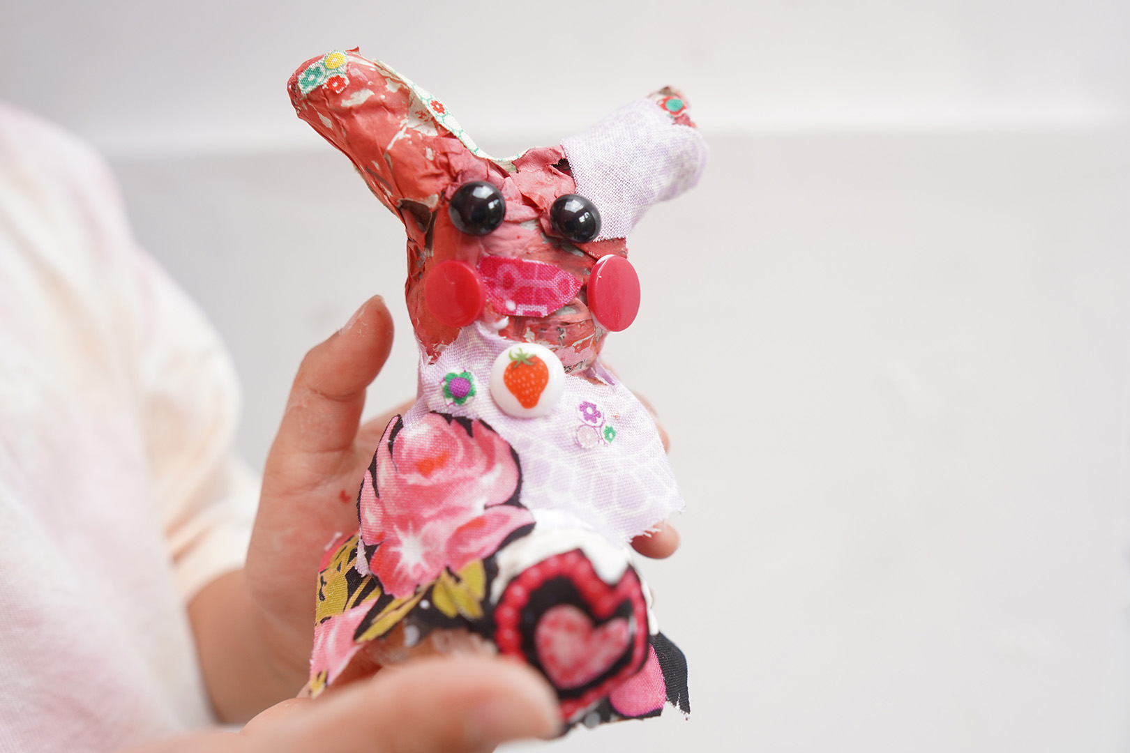 ピンク色のかわいい耳の長いオブジェを見せてくれている子供