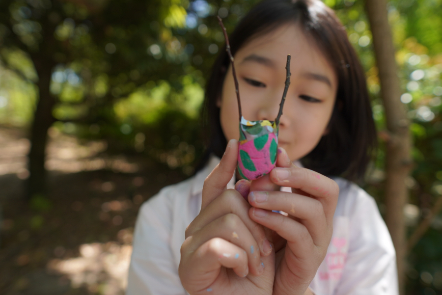 作品を見せてくれている子供の写真